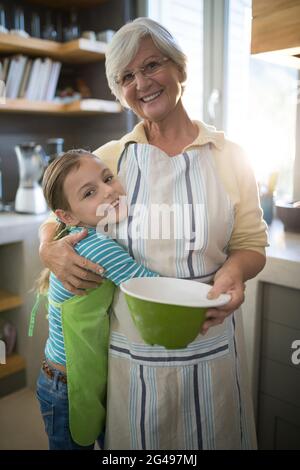 Nonna e nipote abbracciano in cucina Foto Stock