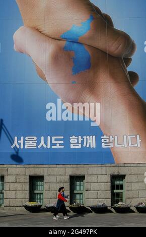 21 aprile 2018-Seoul, Corea del Sud-gente cammina da un banner che mostra una mappa della penisola coreana per desiderare un vertice intercoreano di successo il 21 aprile 2018 a Seoul, Corea del Sud. Il vertice intercoreano è previsto il 27 aprile 2018 presso lo spazio comune di sicurezza di Panmunjom, concordato dal presidente sudcoreano Moon Jae-in e dal leader nordcoreano Kim Jong-un. Foto Stock