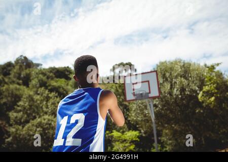 Vista posteriore del ragazzo adolescente che pratica il basket Foto Stock