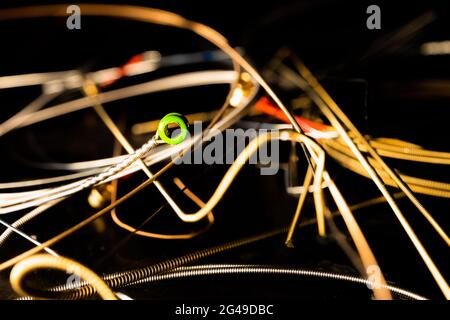 Primo piano di Green Ball End sulla chitarra String davanti al pile delle corde di chitarra in bronzo usate Foto Stock