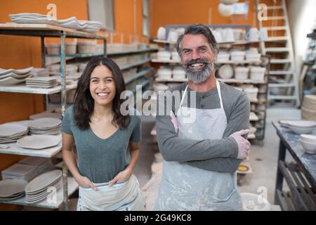 Vasaio maschio e femmina in piedi in laboratorio di ceramica Foto Stock