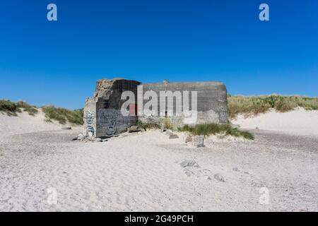 Primo piano vista di un vecchio bunker sulle spiagge di Skagen, nel nord della Danimarca, sotto un cielo blu Foto Stock