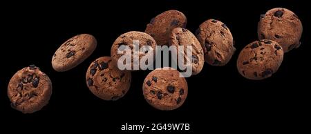 Biscotti al cioccolato che cadono su sfondo nero Foto Stock