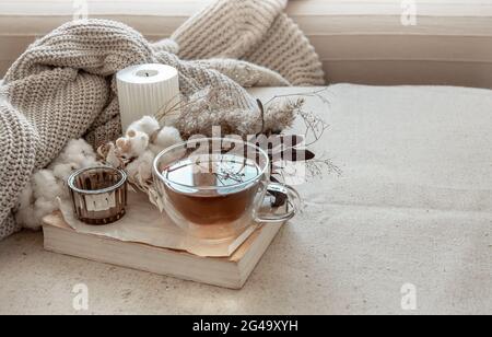 Ancora vita in stile scandinavo con una tazza di tè, un elemento lavorato a maglia e uno spazio per la copia del libro. Foto Stock