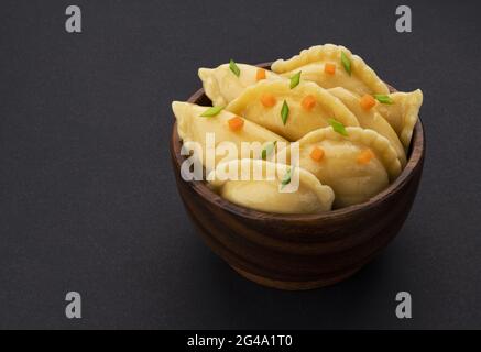 Gnocchi, vareniki russo, pelmeni su sfondo nero Foto Stock