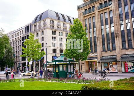Scena cittadina nel centro di Düsseldorf, Germania. La storica Corneliusplatz con edicola d'epoca, hotel e grandi magazzini. Foto Stock