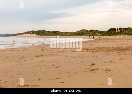 Beadnell, Northumberland, Regno Unito. 20 Giugno 2021. Gli escursionisti e i joggers del cane sono i primi ad arrivare su una spiaggia altrimenti vuota in Beadnell Bay, Northumberland, in una mattina opaca. Il tempo più luminoso è previsto più tardi questo pomeriggio. Peter Lopeman/Alamy Live News Foto Stock