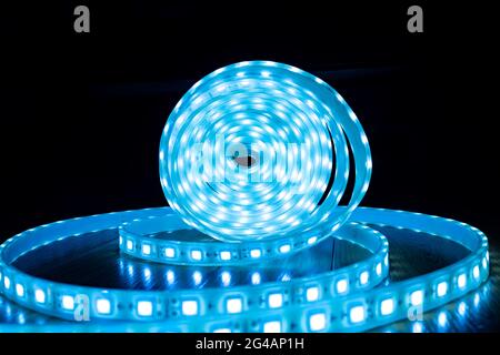 babin di LED decorativo brillante striscia di colore blu freddo su uno sfondo nero. Foto Stock