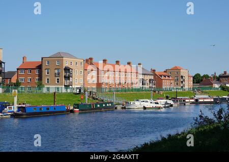 Moderni edifici di appartamenti e barche lungo la riva Witham in una giornata di sole estate. Foto Stock