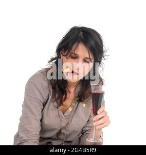 giovane donna beve vino rosso studio girato su sfondo bianco Foto Stock