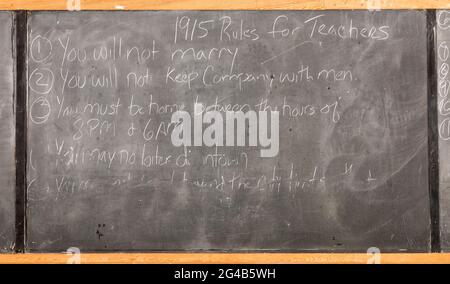 Regole per gli insegnanti nel 1915 scritte sulla lavagna scolastica, città fantasma di Bannack, Montana, Stati Uniti Foto Stock