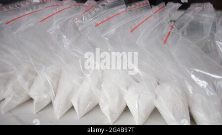 Un gran numero di bustine trasparenti riempite di polvere bianca. Polvere bianca confezionata in bustine piccole. Foto Stock
