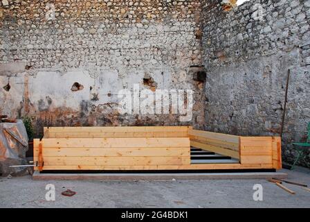 Una base in cemento per la costruzione di una piccola cabina prefabbricata in legno. Le travi di fondazione in legno della cabina sono state posizionate sulla base in calcestruzzo Foto Stock