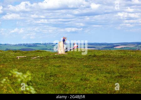 Due persone che riposano per un drink presso un punto di Tig mentre camminano lungo sentiero nazionale lungo le mura di Adriano nel Northumberland Foto Stock