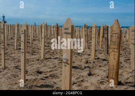 L'Aia, Paesi Bassi. 20 Giugno 2021. Cartelli in legno con i nomi delle vittime visti durante il memoriale. Il giorno della ‘Giornata Mondiale dei rifugiati', le persone di tutta Europa commemorano le 44,000 vittime morte ai confini europei negli ultimi anni. Sulla spiaggia di Scheveningen, vicino al mare è stato collocato un monumento commemorativo a comparsa per pagare l'ultimo rispetto alle vittime. Il monumento commemorativo consisteva di 44,000 cartelli commemorativi che si stessero dalla sabbia sulla spiaggia con i nomi delle vittime scritti su di loro. (Foto di Ana Fernandez/SOPA Images/Sipa USA) Credit: Sipa USA/Alamy Live News Foto Stock