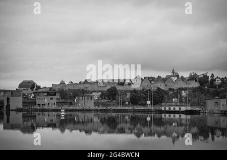 Lauffen am Neckar, Baden-Württemberg, Germania: Diga e serratura nel fiume Neckar con la sagoma della città medievale muro sul retro. Foto Stock