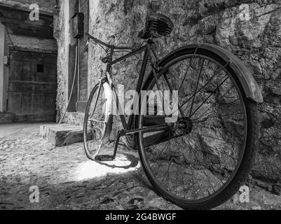 Vecchia bicicletta in un vicolo di un villaggio italiano Foto Stock