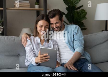 Sorridente giovane coppia che utilizza un tablet per computer digitale. Foto Stock