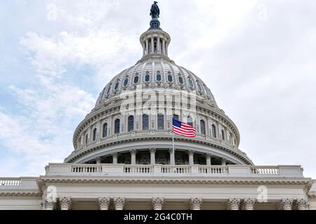 The Dome - una vista ravvicinata e bassa di una bandiera nazionale degli Stati Uniti che vola di fronte alla cupola del Capitol Building. Washington, D.C., Stati Uniti. Foto Stock