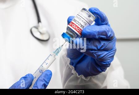 Vaccino COVID-19 nelle mani del medico da vicino, il medico contiene siringa e flacone di vaccino del coronavirus. Concetto di vaccinazione, immunizzazione, iniezione e. Foto Stock