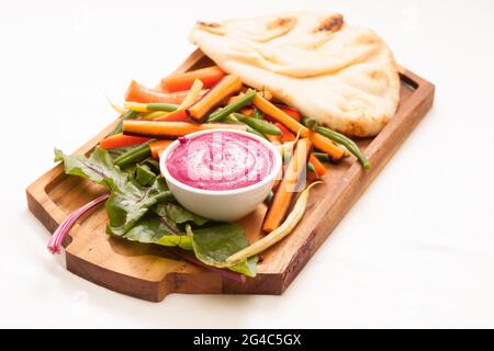 Un tuffo ad alto angolo di barbabietola con pane piatto di naan al forno e bastoncini di verdure per tuffarsi Foto Stock