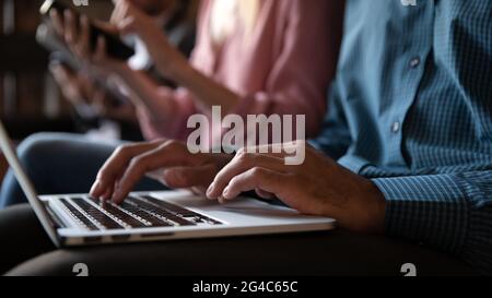 Primo piano irriconoscibile giovane africano che scrive sul laptop. Foto Stock