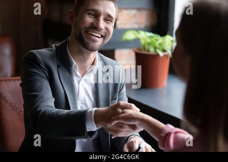 Felice giovane uomo scuotendo le mani con la donna. Foto Stock