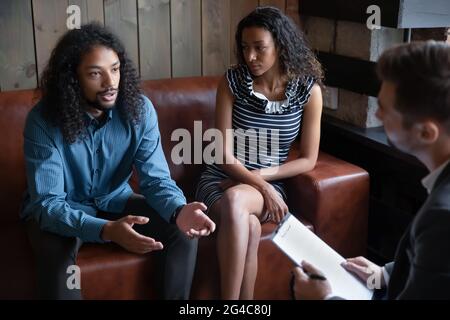 Infelice giovane famiglia afroamericana consulenza con psicologo professionista. Foto Stock