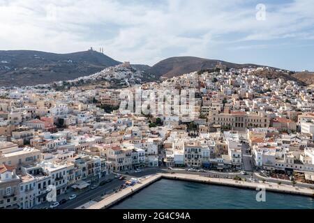 Isola di Syros, Grecia, Ermoupolis e Ano Siros vista aerea drone città. sfondo cielo blu nuvoloso. Hermoupolis, dal porto fino alle colline Foto Stock