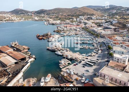 Isola di Syros, Grecia, porto di Ermoupolis vista aerea drone. Barche ormeggiate presso il porto turistico di yacht. Impianto industriale cantiere navale di Neorion e paesaggio urbano, calmo w Foto Stock