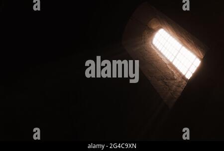 Interno scuro della chiesa con finestra luminosa, sfondo religioso astratto Foto Stock