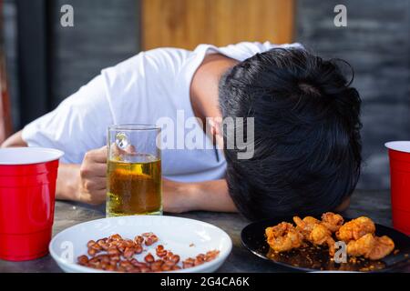 Sbornia dopo una festa di birra, noci e patatine fritte. Foto Stock