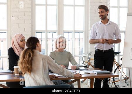 Il Business Coach sicuro risponde alle domande dei dipendenti durante la riunione Foto Stock