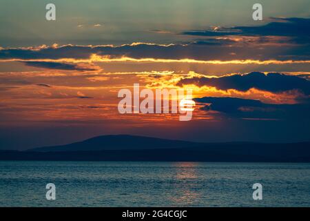 Morecambe, Lancashire, Regno Unito. 20 Giugno 2021. I tramonti dietro Black Coombe nel Sud Cumbrian Fells Credit: PN News/Alamy Live News Foto Stock