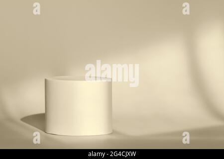 Piedistallo rotondo beige per la presentazione del packaging sullo sfondo con ombre della stanza dalla finestra.palco circolare per i prodotti cosmetici con Foto Stock