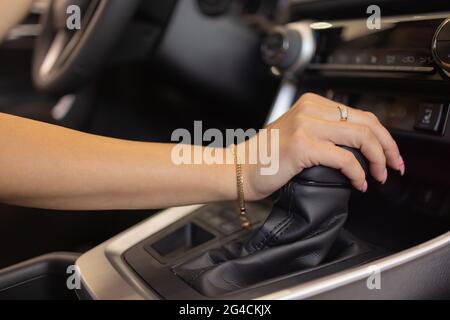 Primo piano della mano di una donna sul volante in una auto moderna Foto Stock