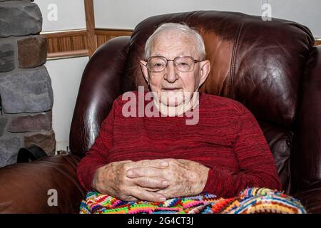 Uomo anziano a 97 anni di età che si rilassa sulla sedia reclinabile. Foto Stock