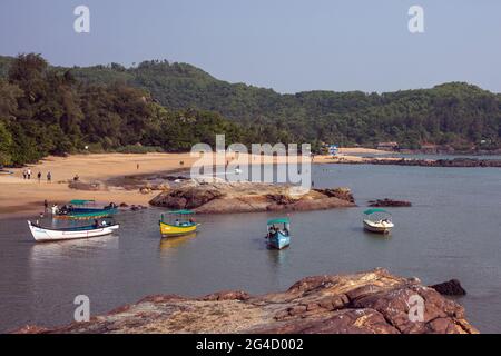 Barche da pesca sparse sull'acqua a Om Beach, Gokarna, Karnataka, India Foto Stock