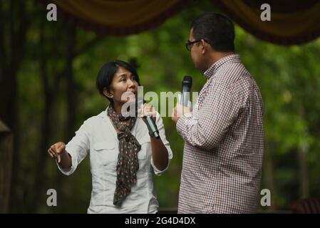 La trasmissione indonesiana di notizie presentatore Desi Anwar e Muhammad Farhan che ha un talk show sul parco nazionale e la conservazione della natura sul palco, durante un evento tenuto dal Ministero delle foreste indonesiano nel Parco Nazionale Kambas di Way, Lampung, Indonesia. Foto Stock