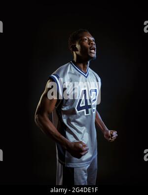 Un giocatore di basket aggressivo si pone in studio Foto Stock