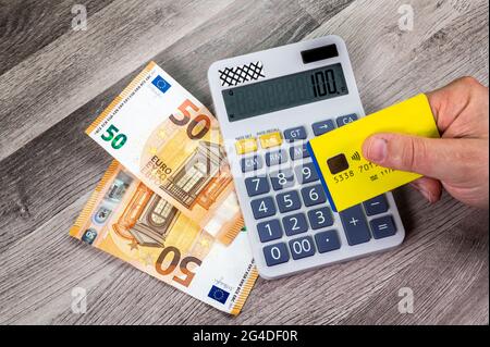 50 euro banconote carta di credito con calcolatrice primo piano su tavolo di legno Foto Stock
