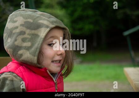 In primavera, la bambina in una felpa con cappuccio camouflage sta camminando nel Parco Nazionale Abant. Selective Focus Girl Foto Stock