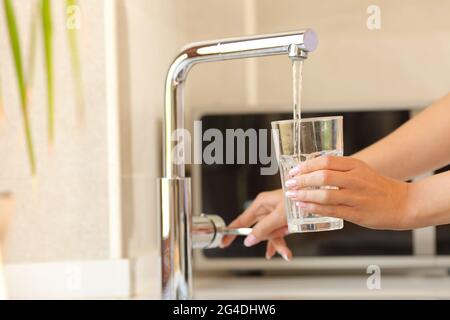 Primo piano di una donna che riempie un bicchiere d'acqua del rubinetto Foto Stock