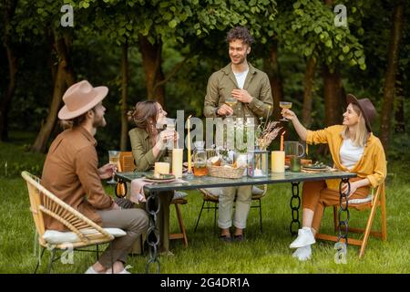 Amici che hanno una cena festosa in natura Foto Stock