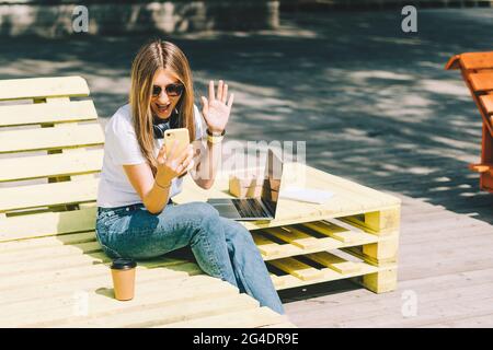 Donna in cuffia che ha una videochiamata. Foto Stock