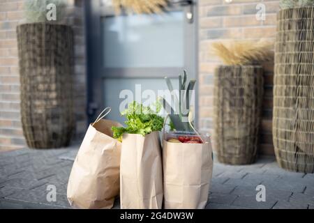 Generi alimentari sul portico di fronte alla porta della casa Foto Stock