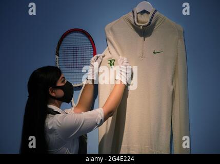 Un tecnico di Christie con il campione cardigan di Roger Federer, Wimbledon, 2012, con una stima di £40,000-60,000, presso Christie's a Londra, uno degli articoli della Roger Federer Collection che sarà offerto all'asta il 23 giugno, con i proventi che vanno alla Fondazione RF. Data immagine: Lunedì 21 giugno 2021. Foto Stock