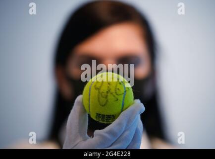 Un tecnico di Christie che detiene una delle palle da tennis firmate da Roger Federer Champion, Madrid, 2012, con una stima di Â£500-800, presso Christie's a Londra, uno degli articoli della Roger Federer Collection che sarà offerto all'asta il 23 giugno, con proventi che vanno alla Fondazione RF. Data immagine: Lunedì 21 giugno 2021. Foto Stock