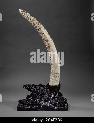 . Posizione emergata elefante su standard verso l'alto aperto con figure ed edifici. Fronte: Sopra il centro di Annie Hermine Cremer-Hogan Brisket, moglie di J.th. Cremer, usato a sinistra. Ha capelli corti e un ramo sulla testa. Abito con collo quadrato e collana corta e lunga. Elenco interno in verticale. Iscrizione interna sotto senza decorazioni. Completamente curato ulteriormente con figure umane e bambini tra alberi con rosette nel mezzo. Molti con il segno di testo o banner in mano. Bordo inferiore: Fondo roccioso su cui si svolge la scena. Appartenuto su standard di legno. Foto Stock