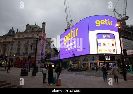 Londra, Regno Unito, 20 giugno 2021: Getir, servizio di consegna di generi alimentari, pubblicizza sugli schermi giganti di Picadilly Circus. Getir è una delle numerose aziende che operano fuori dai negozi bui su terreni industriali e riforniscono generi alimentari in appena 10 minuti di ordini da parte dei clienti. Anna Watson/Alamy Foto Stock